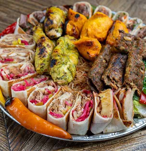 A platter of saj wraps, kebabs and grilled peppers